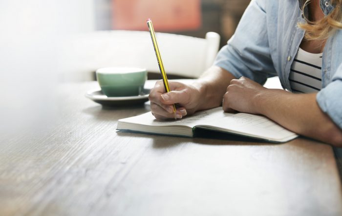 Woman Writing In A Coffee Shop